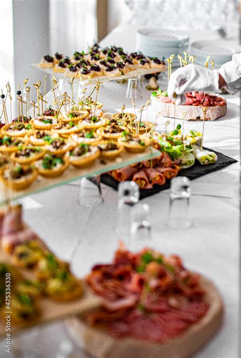 woman hands of a waiter prepare food for a buffet table in a restaurant Stock Photo | Adobe Stock