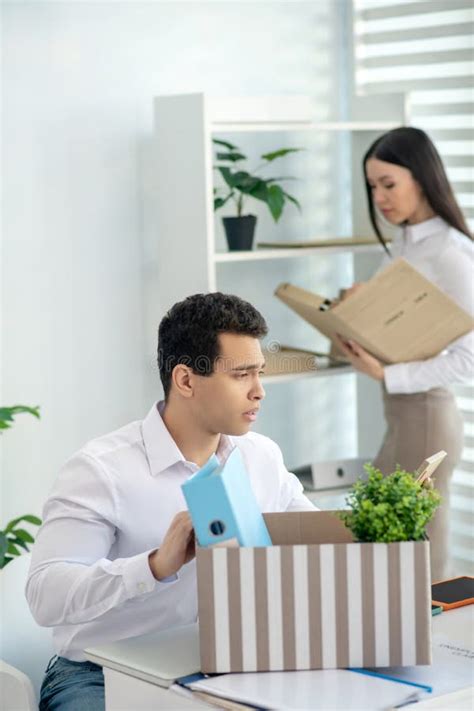 De Beste Jonge Brunette Mannetje Zit Aan Zijn Bureau Zet Zijn Persoonlijke Spullen In De Doos