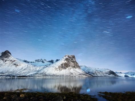 Premium Photo | Mountains and starry night sky senja islands norway reflection on the water ...