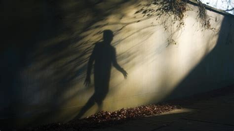 Eerie Silhouette Of A Ghostly Figure On A Wall Premium AI Generated Image