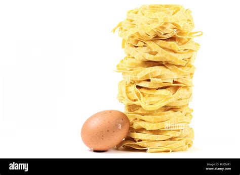 Stack Of Traditional Italian Pasta Tagliatelle Nests With Egg Isolated