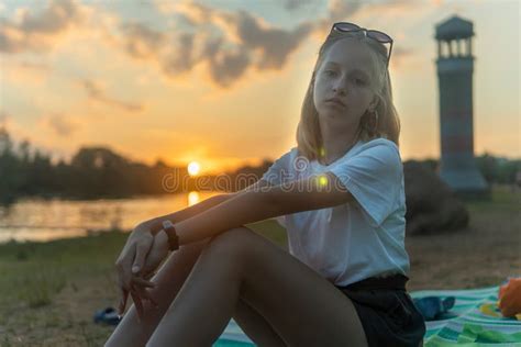Jeune Fille Blonde Assise Au Bord Du Lac Dans Le Parc Et Se Reposant Photo Stock Image Du