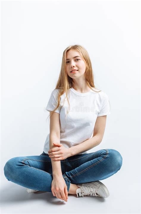 Chica Joven Que Presenta Y Que Sonr E En Un Blonde Delgado Del Fondo Blanco Imagen De Archivo