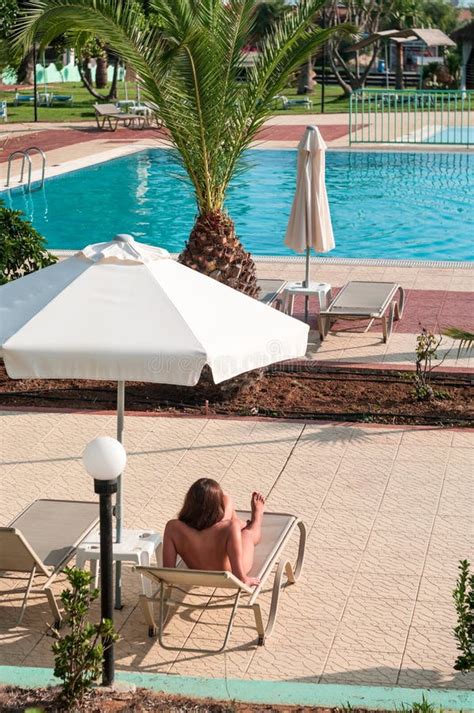 Naked Caucasian Woman Resting Under Sunshade In Shadow Close To