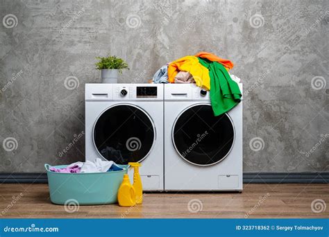 Modern White Washing Machines With Open Door And Laundry Basket In A