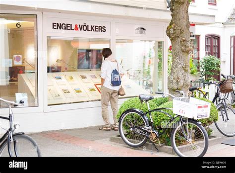 People Watching Offers Of Real Estate In A Shop Window Of Engel And