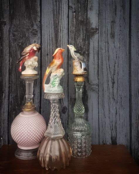 Three Glass Vases Sitting On Top Of A Wooden Table