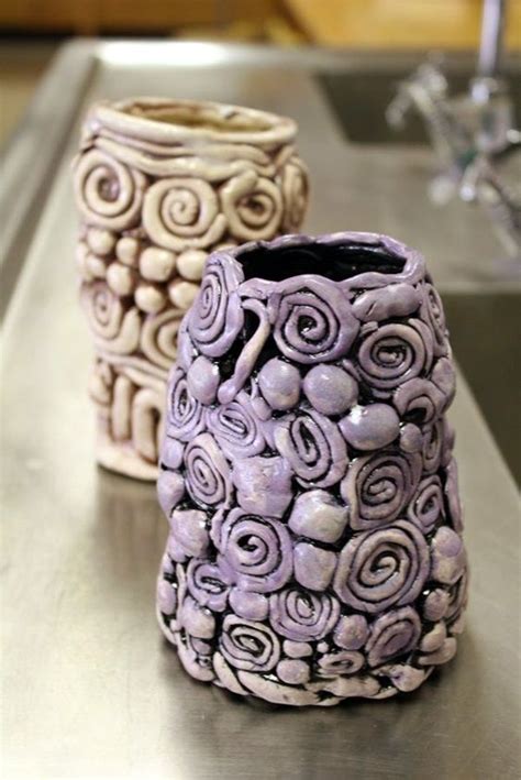 Two Vases Sitting On Top Of A Metal Counter