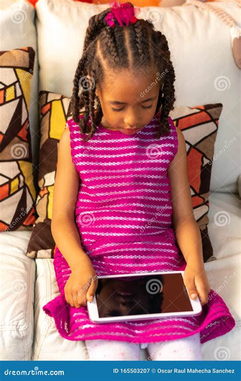 Five Year Old Colombian Afro Descendant Latina Girl Sitting On The Sofa Next To The Christmas