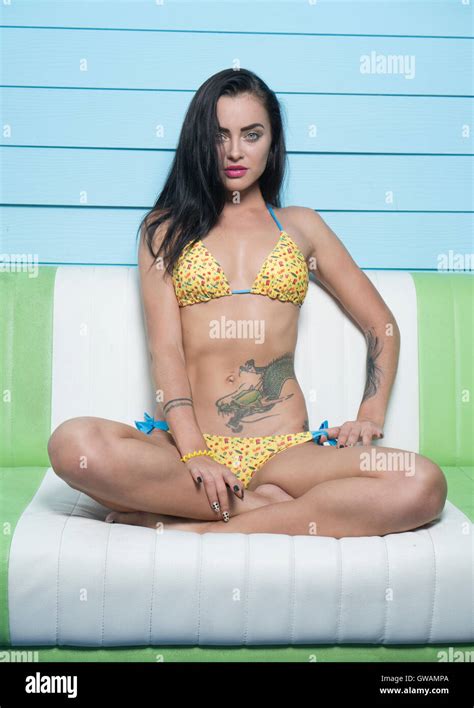 Beautiful brunette woman wearing bikini jaune à la recherche dans l