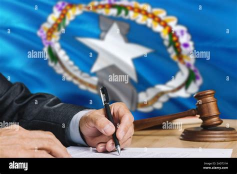 Judge Writing On Paper In Courtroom With Northern Mariana Islands Flag