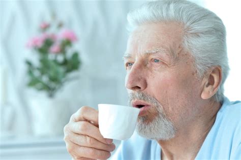 Premium Photo Portrait Of Smiling Senior Man Drinking Coffee At Home