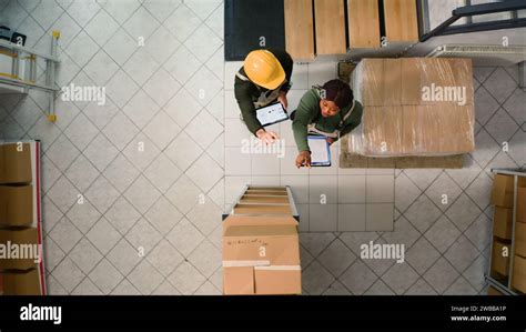 Top Down View Of Warehouse Employees Comparing Findings After