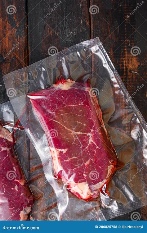 Rump Beef Steak In Vacuum Sealed Bag On Dark Old Wooden Background Top