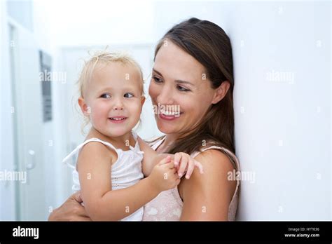 Close Up Portrait Of Mother And Baby Daughter Smiling Indoors Stock