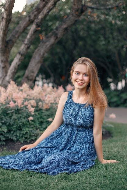 Premium Photo Portrait Of Smiling Young Woman Sitting On Grass