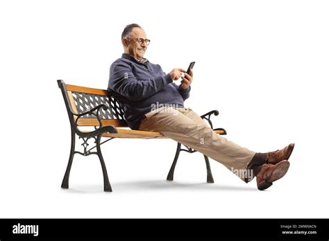 Mature Man Sitting On A Bench And Using A Smartphone Isolated On White