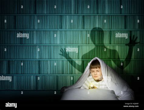 Boy Under The Covers With A Flashlight Stock Photo Alamy