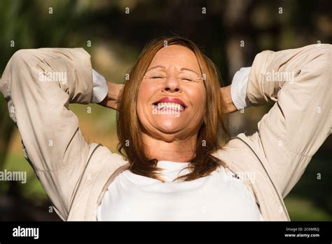 Portrait Attractive Mature Woman Sitting Relaxed And Happy Outdoor