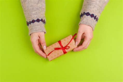 Premium Photo Woman Hands Holding Gift Box On Green Background