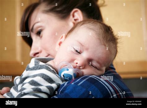 Mother Holding Sleeping Baby Boy Stock Photo Alamy