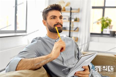 Man Writing To Notebook And Thinking At Home Stock Photo Picture And