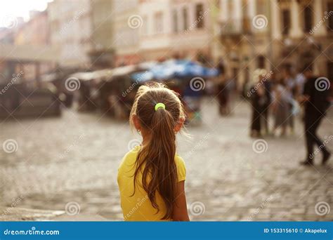 Une Blonde De Petite Fille Examine La Position De Distance Sur La Rue D