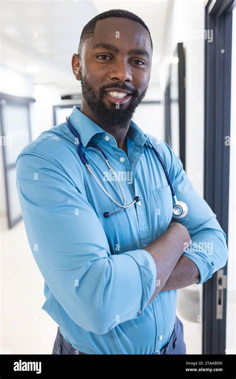 Portrait Of Happy African American Male Doctor Wearing Blue Shirt In