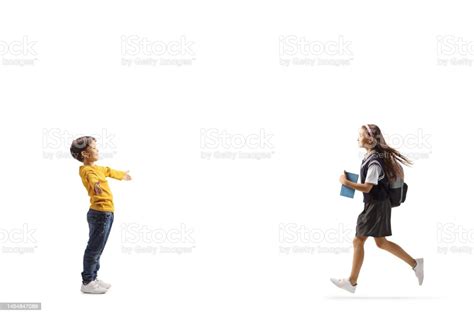 Full Length Profile Shot Of A Schoolgirl Running Towards Her Little