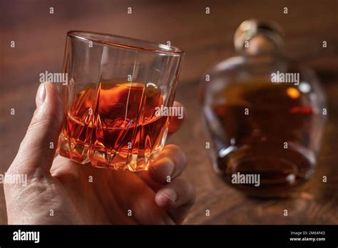 Man Holding Whiskey Glass In Hands On Bottle Background Stock Photo Alamy