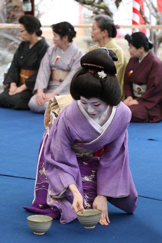 Some People Are Sitting On The Ground With Bowls