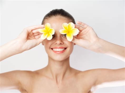 Mujer Alegre Con Flores Amarillas Cerca De La Cara Hombros Desnudos