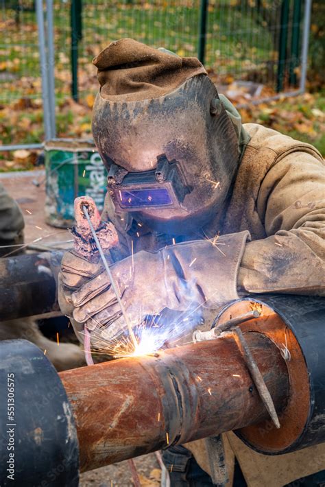 Stockfoto Soudure des tuyaux d un réseau de chaleur par un soudeur