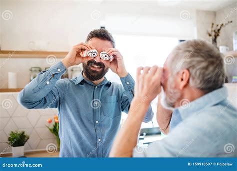 A Portrait Of Adult Hipster Son And Senior Father Indoors At Home