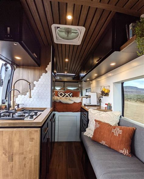 The Kitchen And Living Area Of An Rv With Wood Paneling On The Ceiling