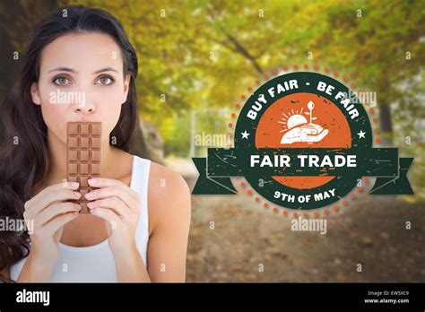 Composite Image Of Pretty Brunette Eating Bar Of Chocolate Stock Photo