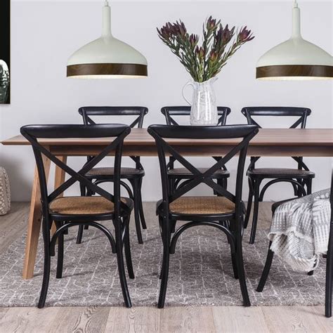 A Dining Room Table With Four Chairs And A Vase On It