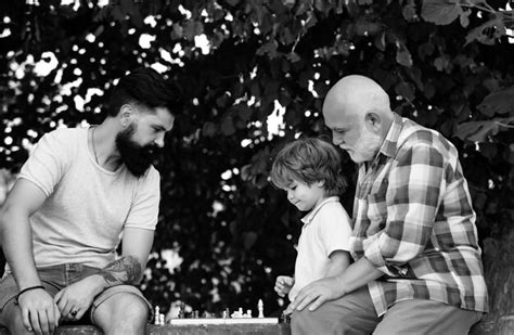 Premium Photo Grandfather And Grandson Are Playing Chess And Smiling