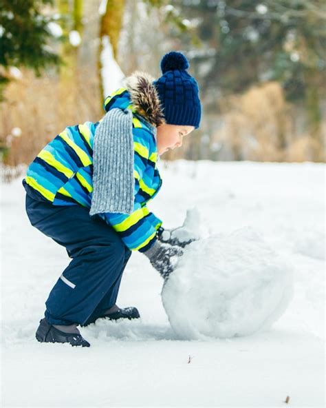 Menino Bonitinho Fazendo Boneco De Neve Rolando Grande Bola De Neve