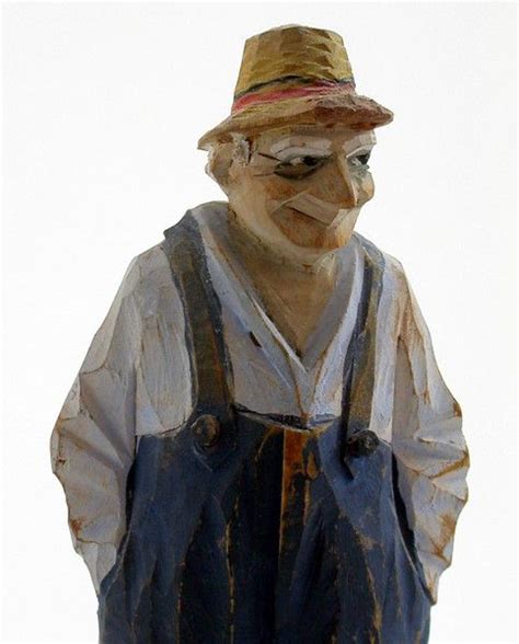 A Statue Of An Old Man Wearing Overalls And A Hat Is Shown In Front Of