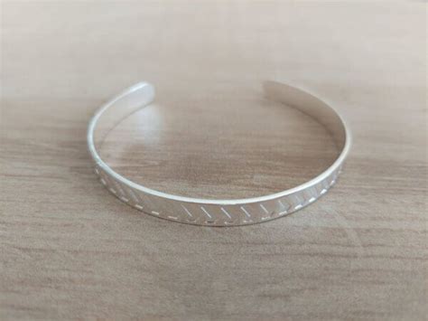 PULSERA DE ACERO BLANCO ESCLAVA ABIERTA CALADO BAJO RELIEVE Zona Once