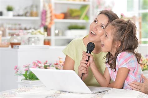 Retrato de madre e hija cantando karaoke con micrófono juntos Foto