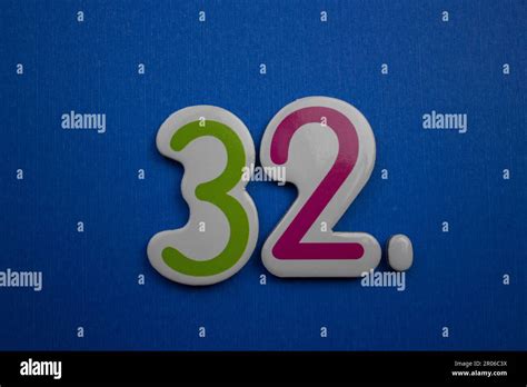 The Number 32 Placed On A Blue Background Photographed From Above