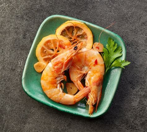 Roasted Prawns With Lemon Slices On A White Plate And Black Background