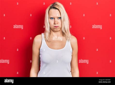 Beautiful Caucasian Blonde Woman Wearing Casual White T Shirt Puffing