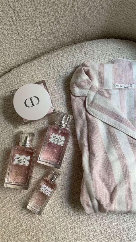 The Contents Of A Purse Are Laid Out On The Couch Next To Some Perfume