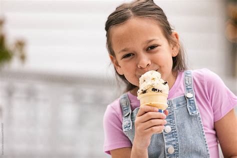 Smiling Girl Enjoys Cookie Ice Cream Cone Del Colaborador De Stocksy