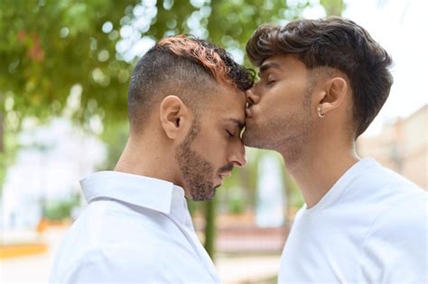 Premium Photo Two Hispanic Men Couple Standing Together Kissing At Park