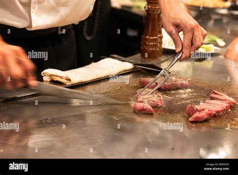 Chef At Teppenyaki Restaurant In Tokyo Japan Slicing Kobe Beef On