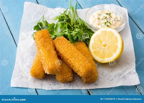 Crispy Fried Fish Fingers With Lemon And Sauce On Blue Wood Stock Image